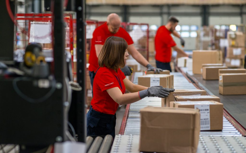 CX+Warehouse+associates+scanning+packages+on+conveyor+belt